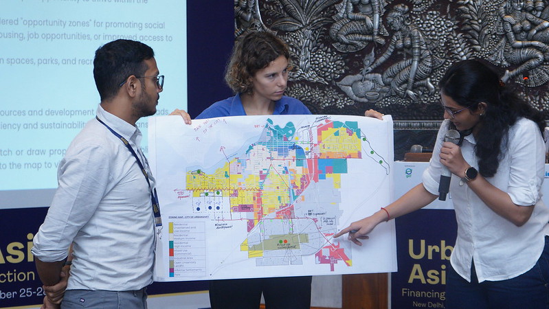 os participantes do curso de acomodação do crescimento urbano examinam um exemplo de mapa de uma área urbana em expansão