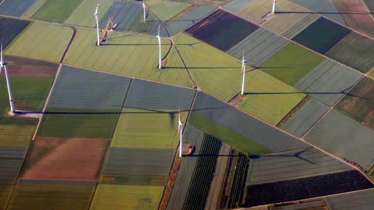 Uma vista aérea de uma fazenda com turbinas eólicas