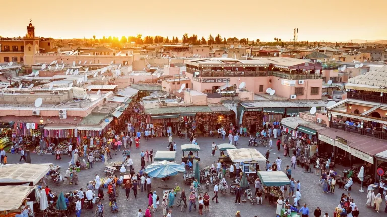 uma fotografia de um movimentado mercado da cidade ao pôr do sol