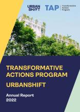 A capa do Relatório Anual do Programa de Ações Transformadoras UrbanShift 2022. A fotografia de um edifício com árvores na frente é contornada por blocos amarelos, azuis e verdes claros.